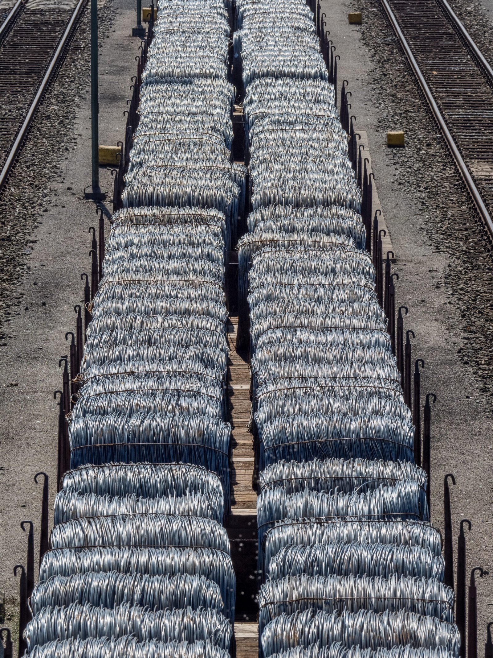 Heavy spools of fiber optic cable staged for aerial installation along rural cooperative utility easements.