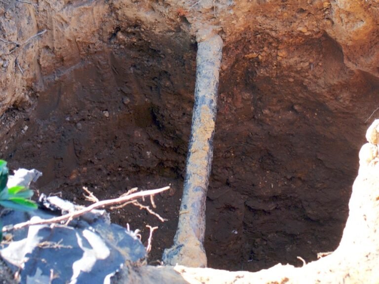 Excavation site uncovering legacy municipal lead water service pipe for infrastructure replacement
