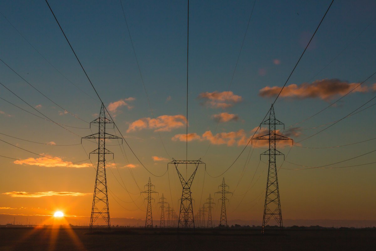 High-voltage steel transmission towers carrying regional electrical power across an open landscape