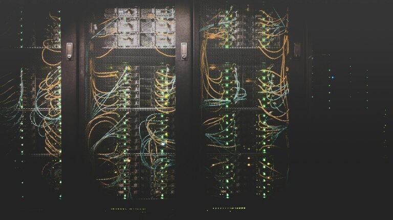 Blue and cyan LED illumination on high-density server rack infrastructure inside an enterprise computing facility