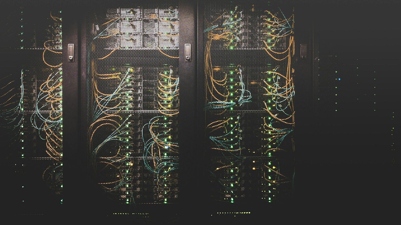Blue and cyan LED illumination on high-density server rack infrastructure inside an enterprise computing facility