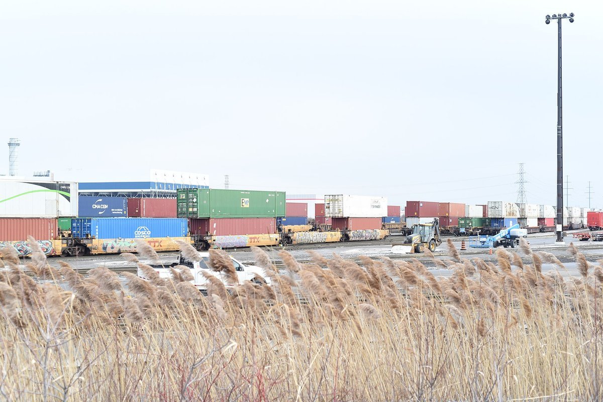 Intermodal freight rail flatcars loaded with shipping containers for inland distribution