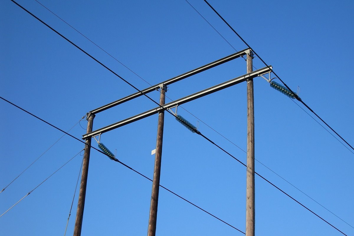 High-voltage electric transmission line traversing winter agricultural terrain in the Upper Midwest